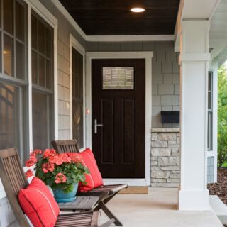 Front porch of house showing chairs and pillows