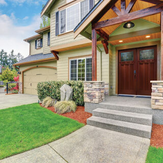 Luxurious home with well kept lawn, and green exterior paint.